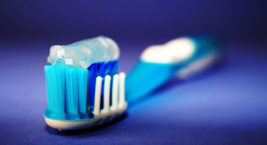 A close up image of a blue toothbrush with sparkle blue toothpaste