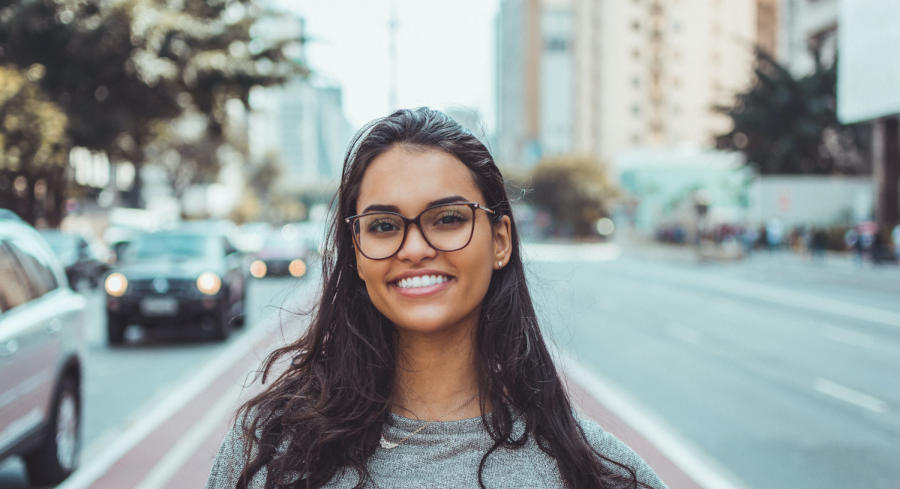 A woman in the city smiling straight at the camera