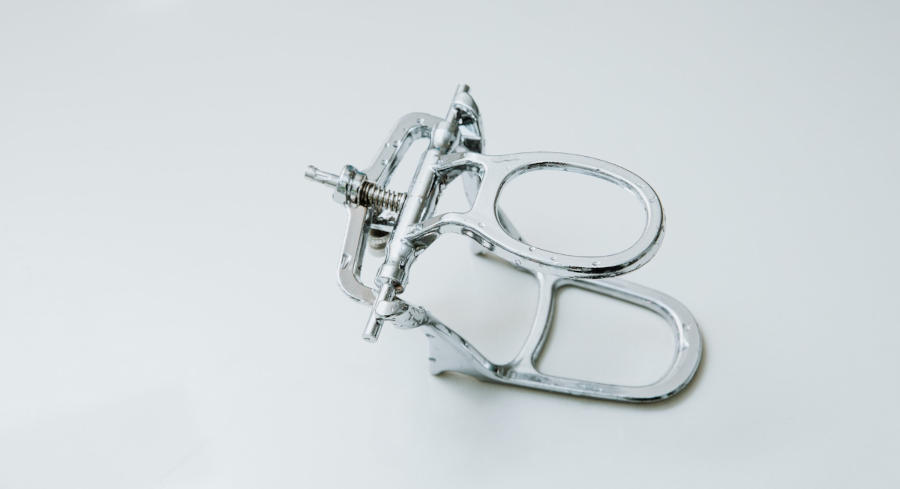 A silver stainless steel palate expander being shown laying on top of a table