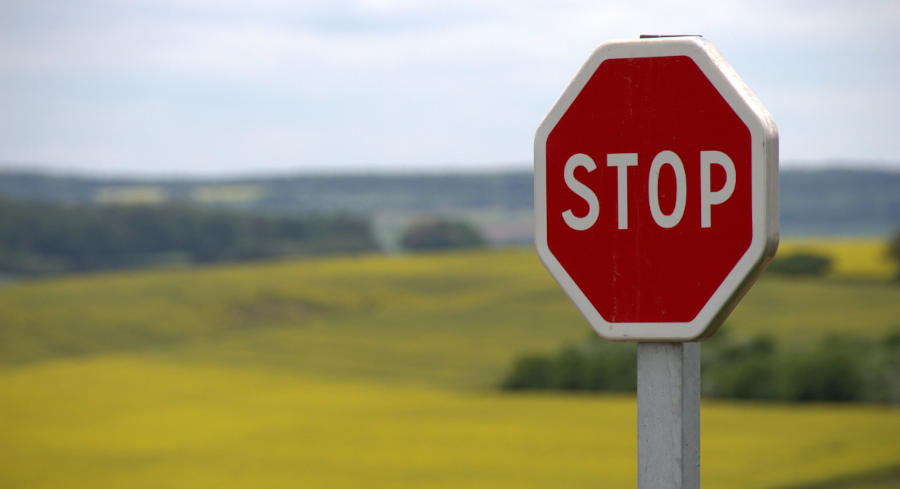 A small red stop sign with a beautiful backcountry background