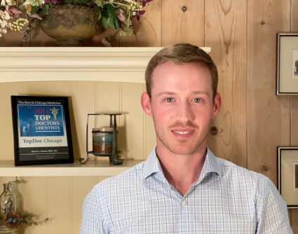 A young man smiling and introducing Skarin Orthodontics